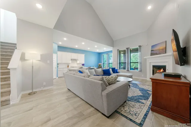 a living room with furniture a flat screen tv and a fireplace