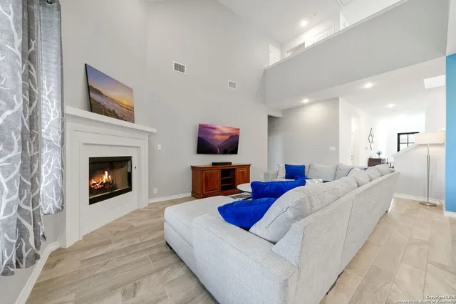 a living room with furniture a fireplace and a flat screen tv