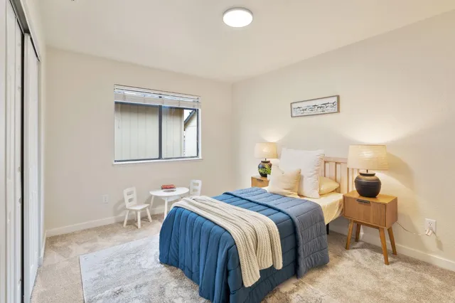 a bedroom with a bed and a lamp with wooden floor