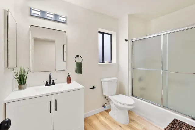 a bathroom with a toilet a sink a mirror and vanity