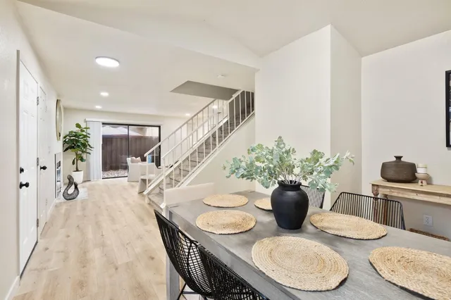 a dining room with furniture and potted plants