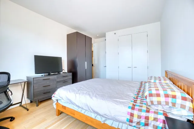 a bedroom with a bed and a flat screen tv