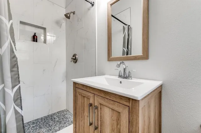 a bathroom with a sink a mirror and a shower