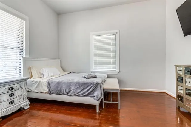 a bedroom with a bed and a tv on the dresser