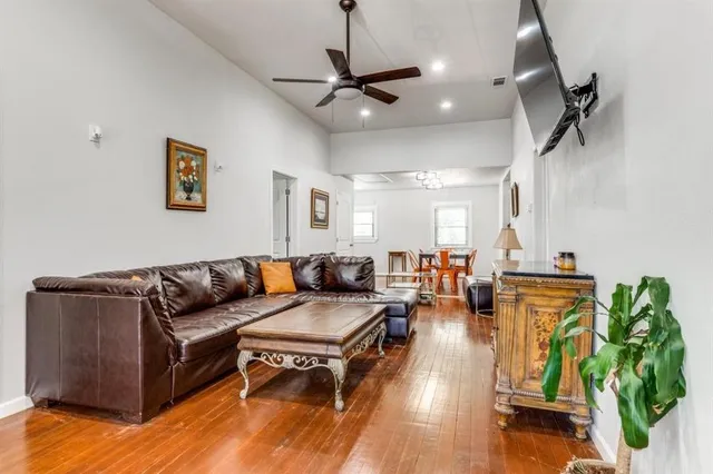 a living room with furniture kitchen view and a chandelier