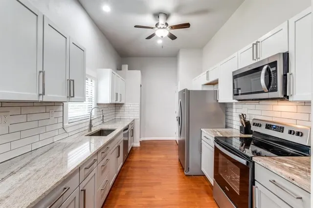 a kitchen with stainless steel appliances granite countertop a stove a sink and a refrigerator