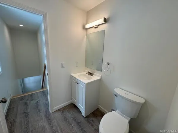 a bathroom with a sink mirror vanity and toilet