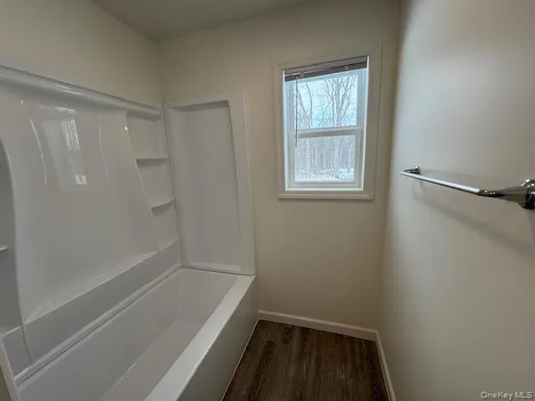 a bathroom with a tub shower and sink