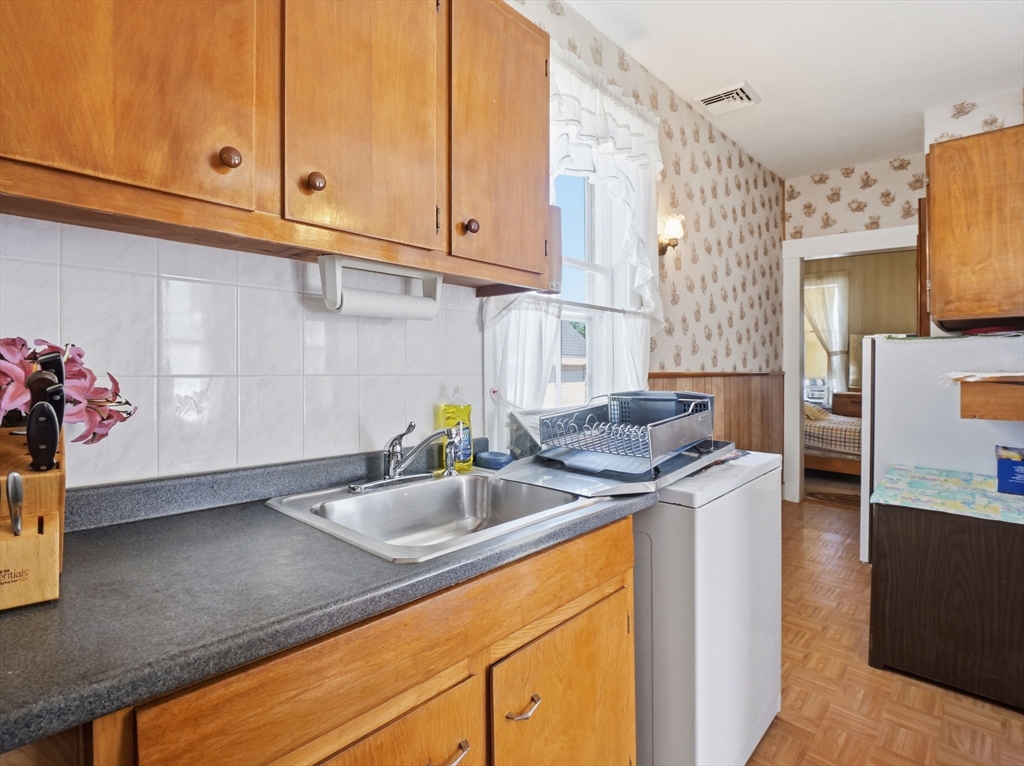 223 Stackpole Street Lowell, MA 01852 - Photo 24 of 42 a kitchen with stainless steel appliances granite countertop a sink stove and cabinets