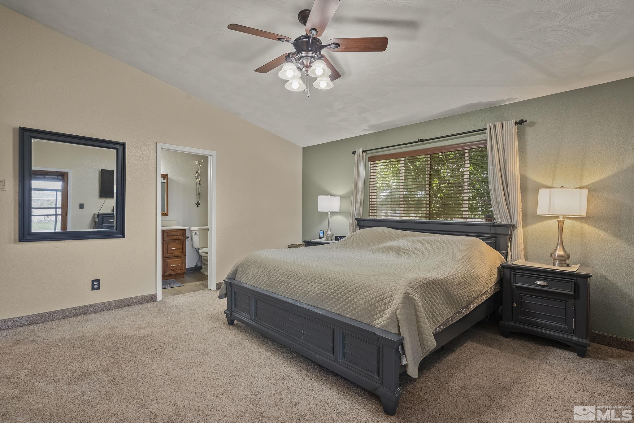 10890 Osage Road Reno, NV 89508 - Photo 16 of 40 a bedroom with a large bed and a chandelier