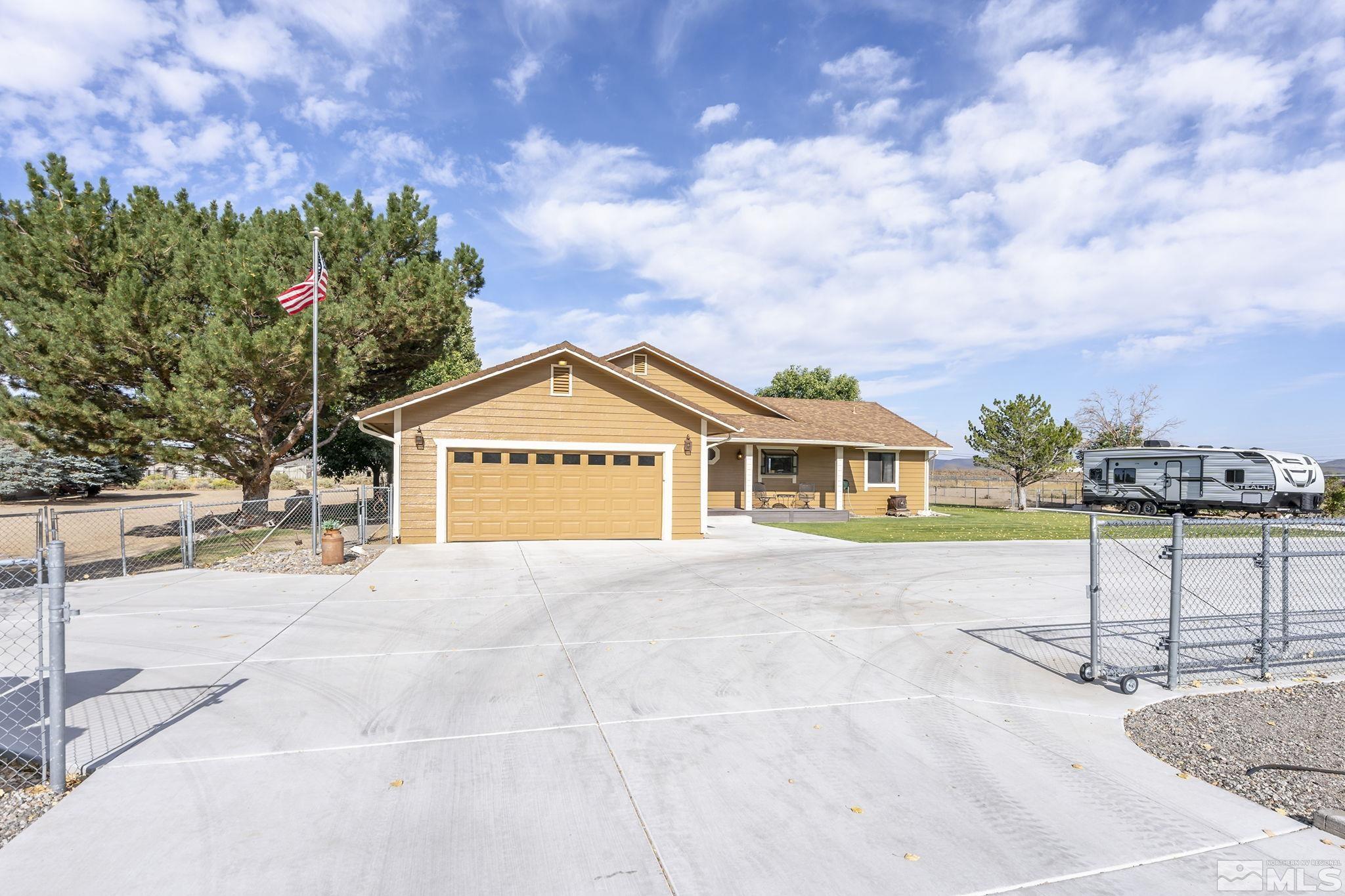 10890 Osage Road Reno, NV 89508 - Photo 2 of 40 a front view of a house with a yard and garage