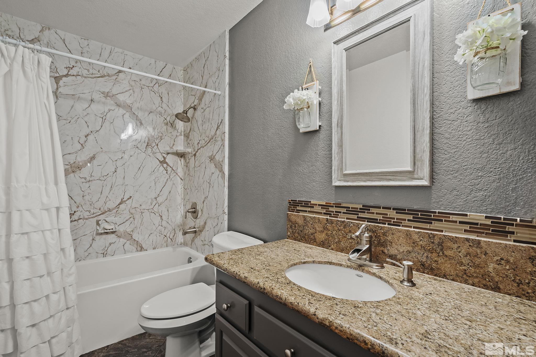 10890 Osage Road Reno, NV 89508 - Photo 23 of 40 a bathroom with a granite countertop sink toilet a mirror and shower