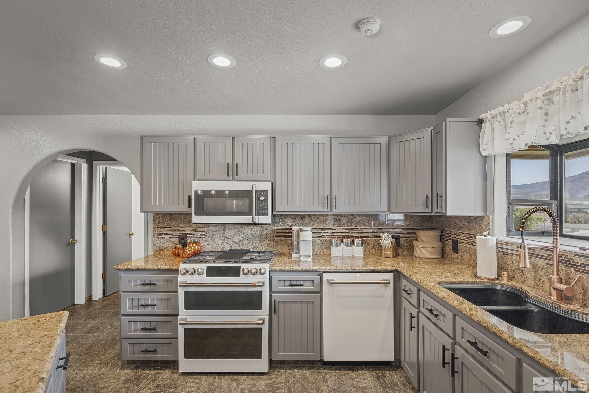 10890 Osage Road Reno, NV 89508 - Photo 9 of 40 a kitchen with stainless steel appliances granite countertop a refrigerator stove and sink