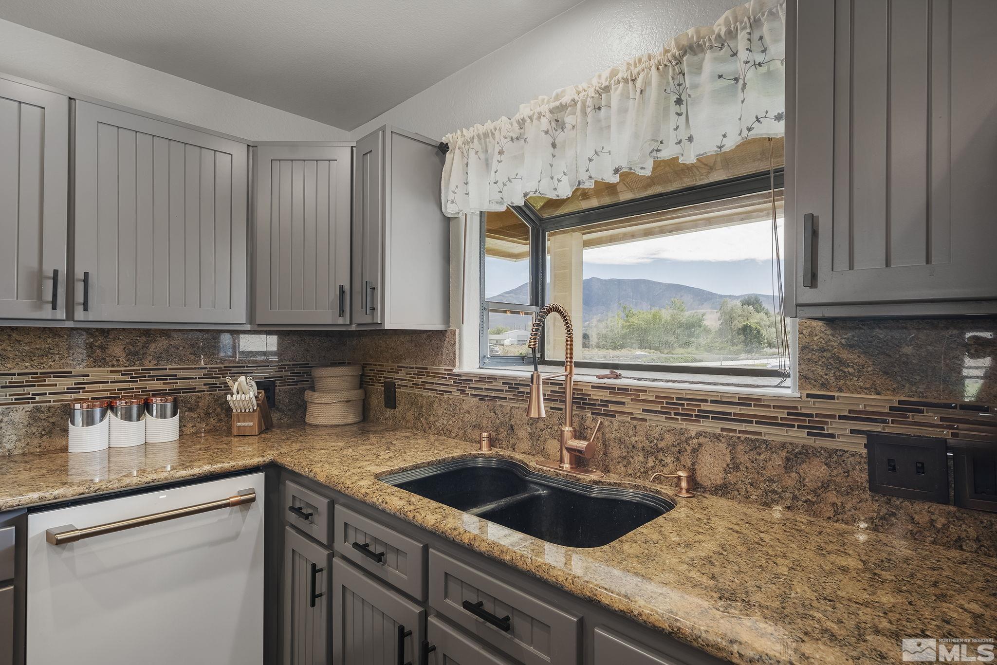 10890 Osage Road Reno, NV 89508 - Photo 10 of 40 a kitchen with granite countertop a sink a counter space and cabinets