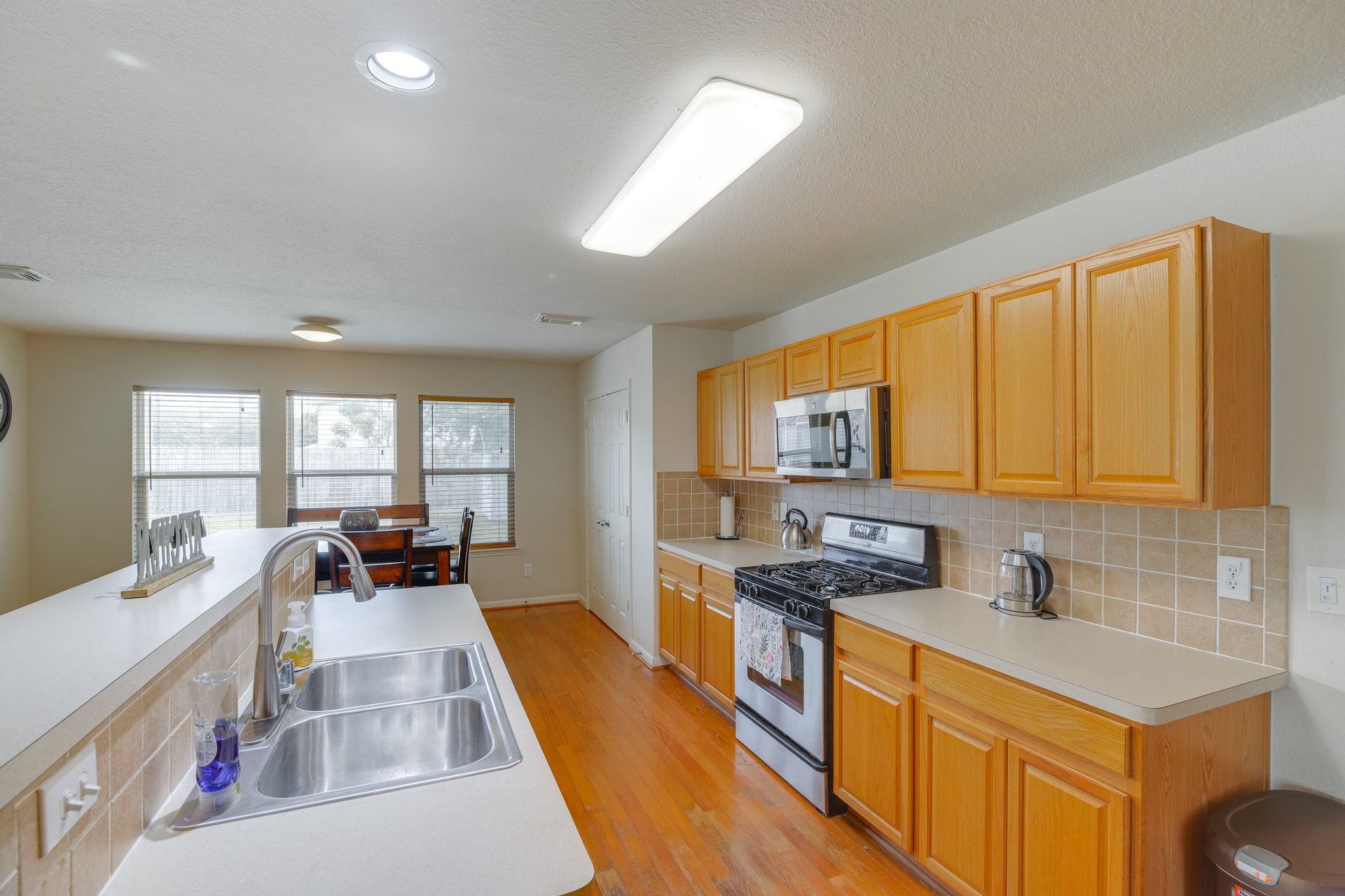 8019 Berkely Court Baytown, TX 77521 - Photo 6 of 13 a kitchen with stainless steel appliances a sink window and cabinets