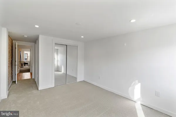 an empty room with closet and a window