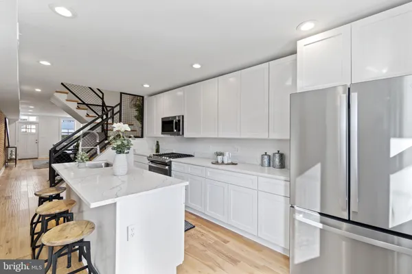 a kitchen with appliances a sink and cabinets