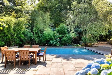 a view of a patio with table and chairs and potted plants