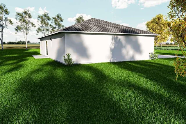 a white house with green field in front of it