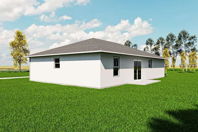 a white house with a small yard and big trees