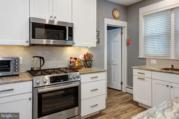 a kitchen with stainless steel appliances granite countertop a stove a microwave and cabinets