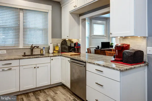 a kitchen with stainless steel appliances granite countertop a sink and a white cabinets