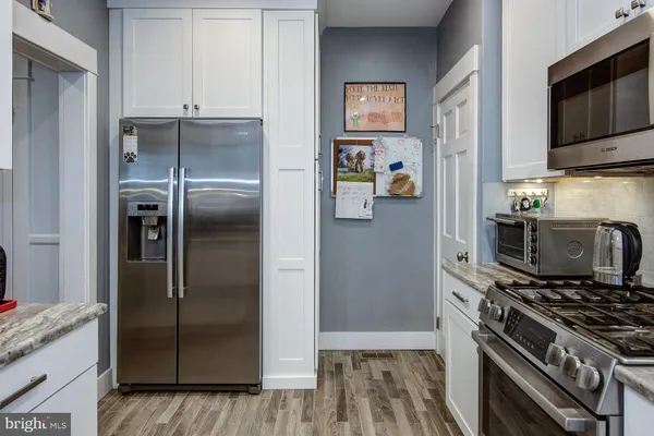 a kitchen with stainless steel appliances granite countertop a refrigerator and a stove