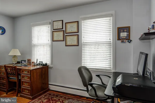 a view of a workspace with furniture and a window