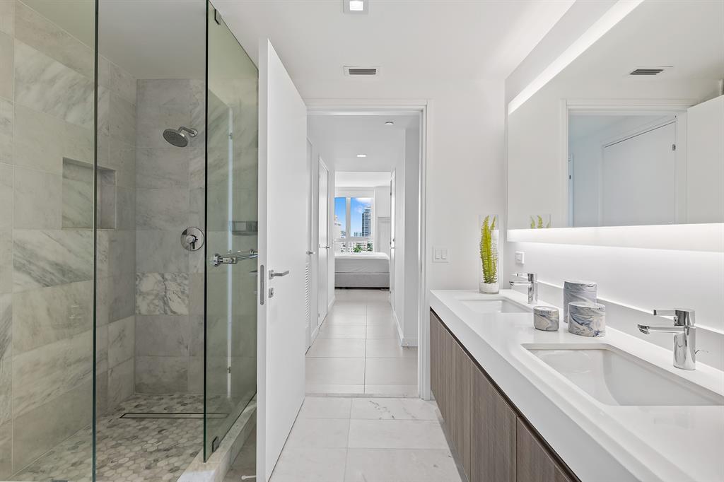 401 North Birch Road, Unit 1003 Fort Lauderdale, FL 33304 - Photo 11 of 26 a bathroom with a granite countertop sink a shower and a mirror