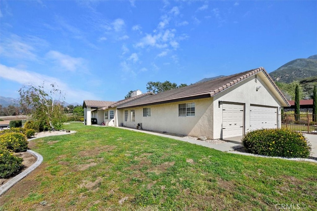 923 Devore Road San Bernardino, CA 92407 - Photo 3 of 75 a view of a yard in front of a house with plants and large tree