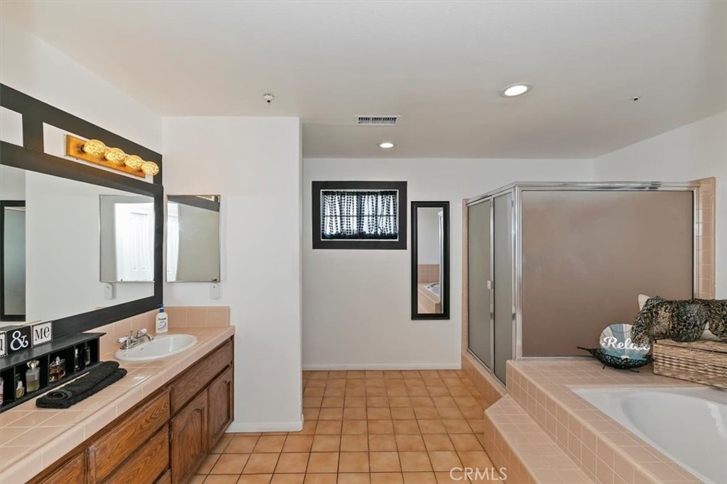 923 Devore Road San Bernardino, CA 92407 - Photo 37 of 75 a spacious bathroom with a mirror a double vanity sink and shower