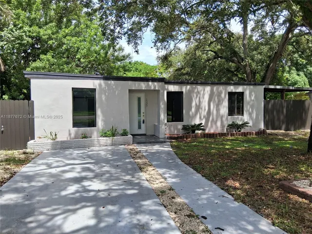a view of a backyard with potted plants and large tree