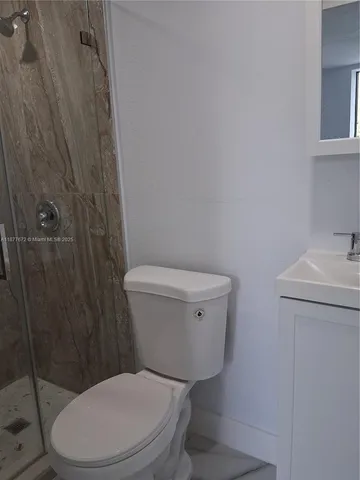 a white toilet sitting next to a bathroom sink