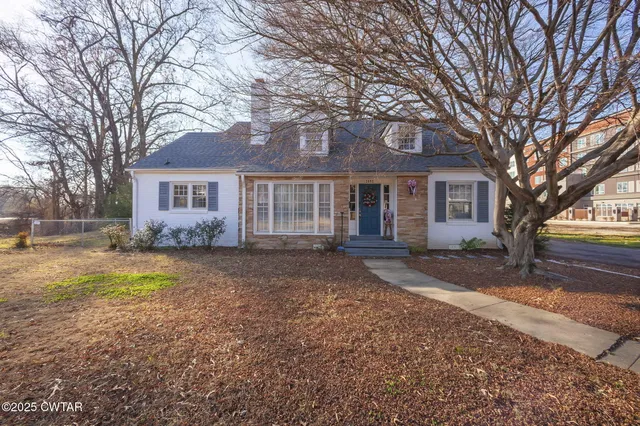 a view of a house with backyard and trees
