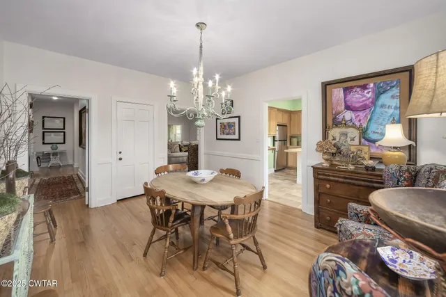 a living room with furniture chandelier and a flat screen tv