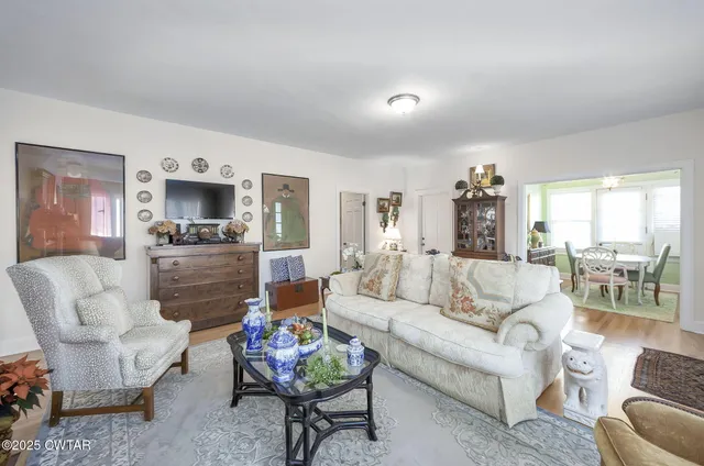 a living room with furniture chandelier and a window