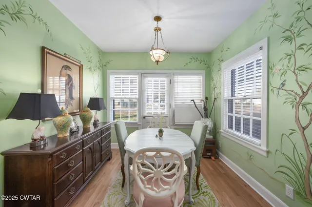 a view of a dining room with furniture wooden floor and a chandelier