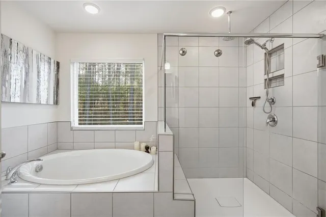 a white bath tub sitting next to a white sink and vanity