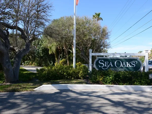 a view of a street sign under a large tree
