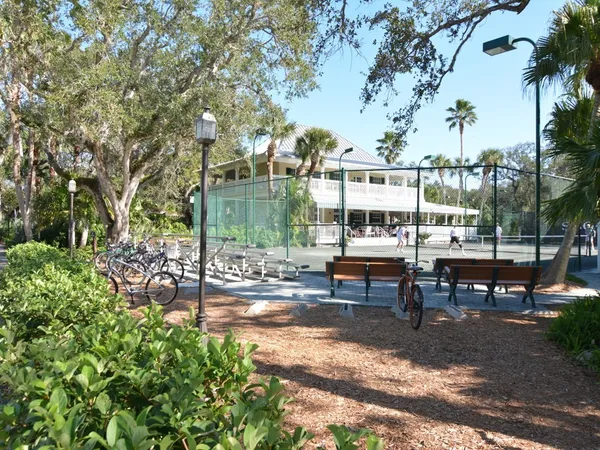 a view of a patio with table and chairs potted plants and large tree
