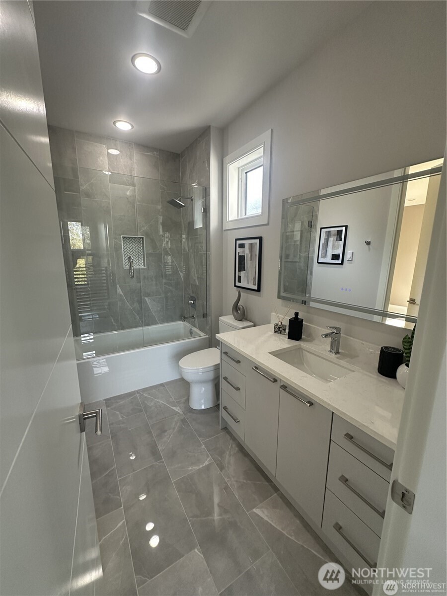4413 Northeast 26th Court Renton, WA 98059 - Photo 18 of 28 a bathroom with a double vanity sink toilet mirror and bathtub