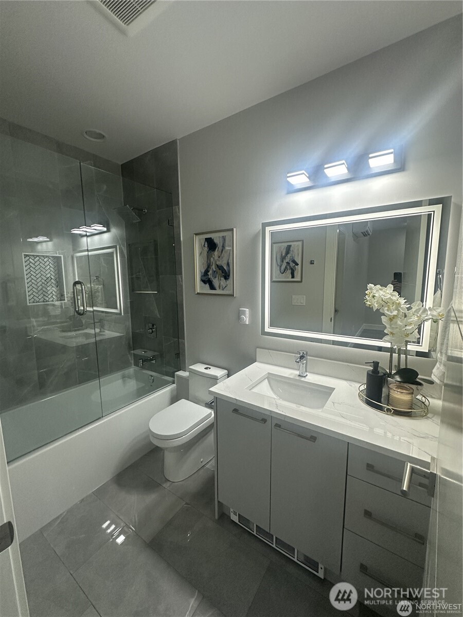 4413 Northeast 26th Court Renton, WA 98059 - Photo 24 of 28 a spacious bathroom with a sink a toilet a mirror and shower