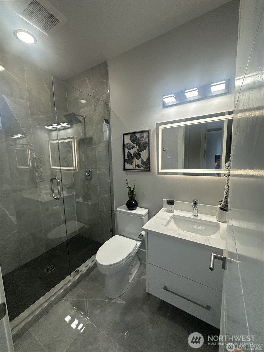 4413 Northeast 26th Court Renton, WA 98059 - Photo 10 of 28 a bathroom with a sink toilet a mirror and shower