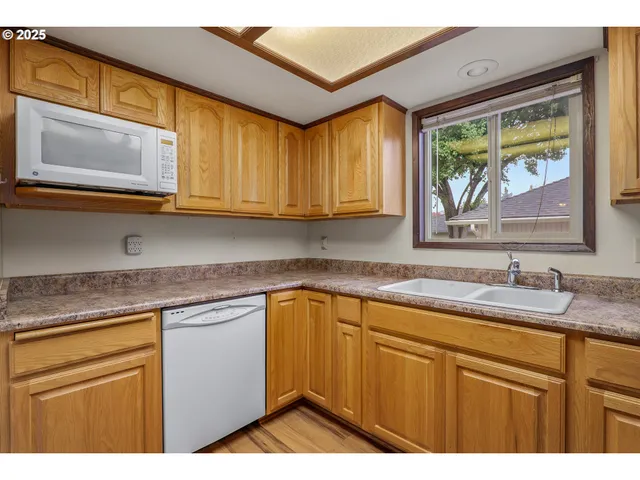 a kitchen with stainless steel appliances granite countertop a sink a stove and cabinets