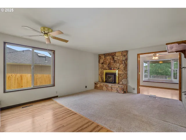 a view of an empty room with a window and a fireplace