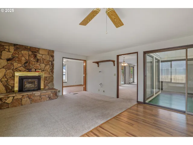 a view of empty room with wooden floor and fireplace