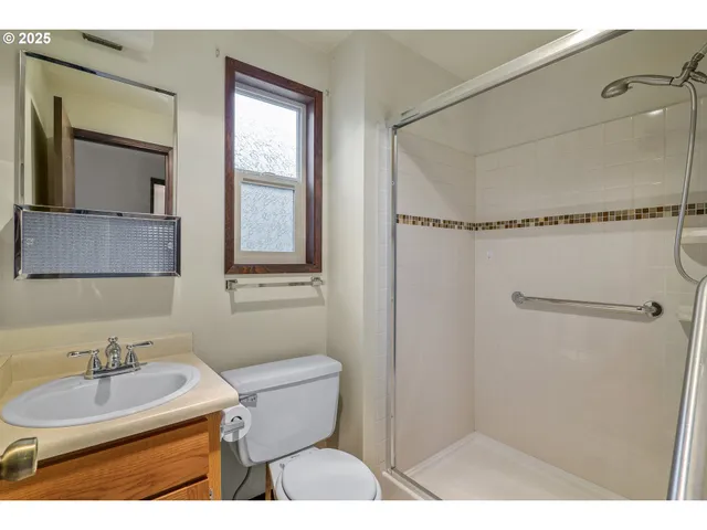 a bathroom with a sink toilet a mirror and shower