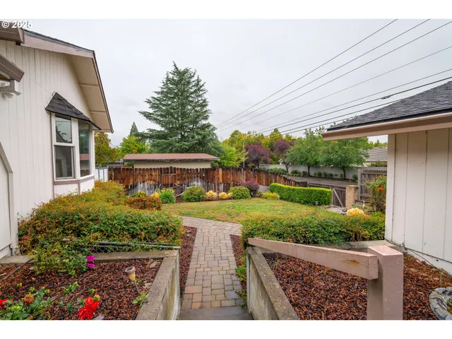 a view of a backyard with plants and a patio
