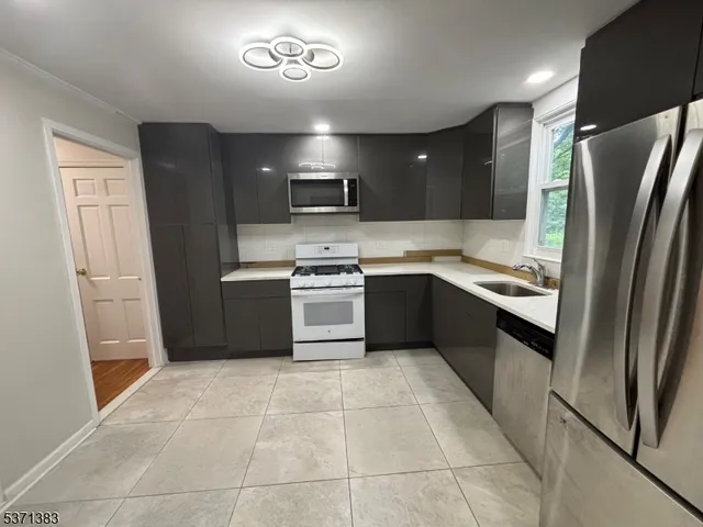 a kitchen with stainless steel appliances granite countertop a refrigerator stove and sink