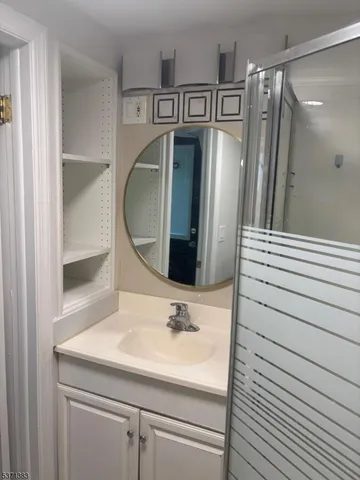 a bathroom with a sink a mirror and shower